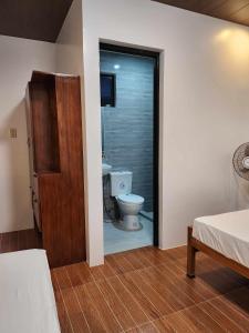 a room with a bathroom with a toilet and a door at Malinawon Hotel Room 3 in General Luna