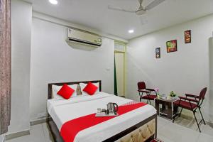 a bedroom with a bed and a table and chairs at Hotel O Sunshine Inn in Nagpur