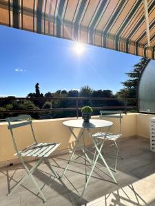 a white table and two chairs on a balcony at STUDIO HORIZON - SEA VIEW - POOL- Air Conditioner - Kitchen - Wifi -TV Train - Bus - in Villeneuve-Loubet