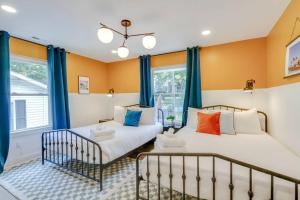 two beds in a room with blue curtains at NashOasis 10 Min to DT, Gameroom, Huge Yard in Nashville