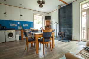 a kitchen and dining room with a table and chairs at Piejūras apartamenti STEAMER in Roja