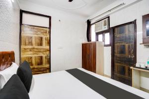 a bedroom with a bed and a window at Super Hotel O The Maruti hotel in Noida +26 photos