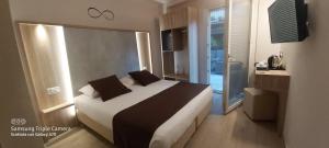 a bedroom with a bed and a large window at Hotel Danieli La Castellana lago di Garda in Brenzone sul Garda
