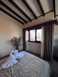a room with a bed with a swan on it at Juliette Posada Boutique in Villa Carlos Paz