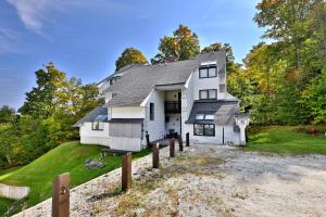 a large white house on a hill with trees at Sunrise Timberline M1- Cozy 2 BR Ski On Ski Off Condo in Killington