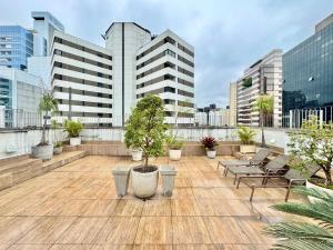 patio na dachu z krzesłami, drzewami i budynkami w obiekcie Flat próximo Av. Paulista Completo c/ Estacionamento e Limpeza w São Paulo
