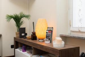 a table with a vase and a lamp on it at Casa Sancarlino - 200mt Clinica Zucchi in Monza