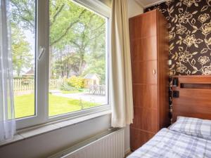 a bedroom with a bed and a large window at Zonnehoek in Exloo