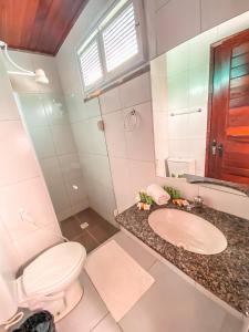 a bathroom with a toilet and a sink at Hotel Sunshine Centro Cumbuco in Cumbuco +14 photos