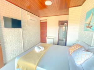 a bedroom with a bed with two towels on it at Hotel Sunshine Centro Cumbuco in Cumbuco