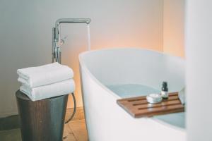 a bathroom with a tub and a pile of towels at Crowne Plaza Merida by IHG in Mérida