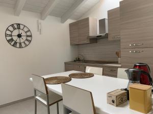 a kitchen with a white table and chairs and a clock at Oasi del Po in Monticelli dʼOngina