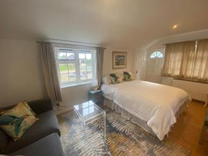 a bedroom with a bed and a couch and a window at The Guesthouse Hideaway by Newfo.rest in Hordle +18 photos