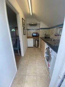 a kitchen with a washing machine in the middle of a room at The Guesthouse Hideaway by Newfo.rest in Hordle
