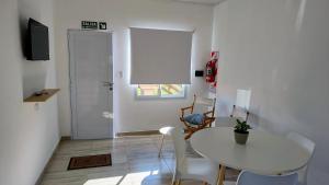 a white dining room with a table and chairs at KUSI Casas de alquiler in Liebig