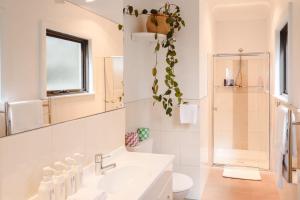 Clarence PointにあるChateau Clarence & Petite Chateau Luxurious Waterfront Retreatの洗面台とトイレを備えた白いバスルーム +110枚の写真