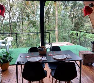 a table with chairs sitting on a deck with a view at Cabana Das Paineiras in Feliz +19 photos