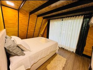 a small bedroom with a bed and a window at Cabana Das Paineiras in Feliz