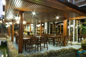 ein Restaurant mit Holztischen und -stühlen und Menschen darin in der Unterkunft Sangsawan Palace Khaolak Resort in Khao Lak