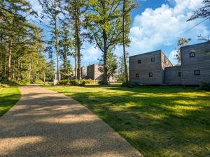 a path leading to two buildings in a park at Stylish Forest Mansion Stay in Antoing