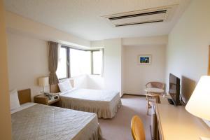 a hotel room with two beds and a window at Seto Park Hotel in Seto