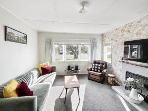 a living room with a couch and a fireplace at Whitianga Blue Bach - Location Location Location! in Whitianga