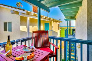 a table with a plate of food and a bottle of wine on a balcony at Balboa Peninsula Hidden Gem with Private Balcony & Stunning Views in Newport Beach