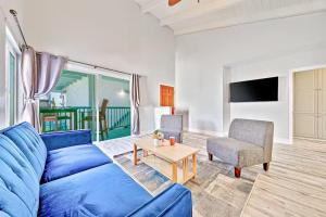 a living room with a blue couch and a table at Balboa Peninsula Hidden Gem with Private Balcony & Stunning Views in Newport Beach