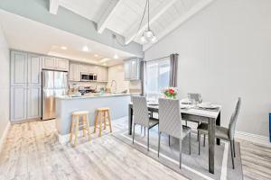 a kitchen and dining room with a table and chairs at Balboa Peninsula Hidden Gem with Private Balcony & Stunning Views in Newport Beach