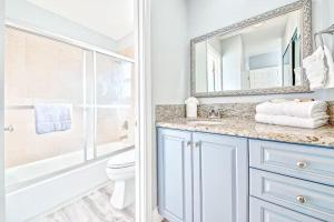 a bathroom with a sink and a toilet and a mirror at Balboa Peninsula Hidden Gem with Private Balcony & Stunning Views in Newport Beach +16 photos