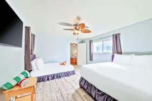 a hotel room with two beds and a flat screen tv at Balboa Peninsula Hidden Gem with Private Balcony & Stunning Views in Newport Beach