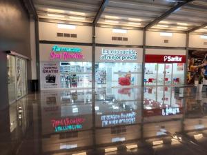 a store with signs on the window of a store at Casa Villa El Escape en Residencial Villa Panamericana in San Miguel