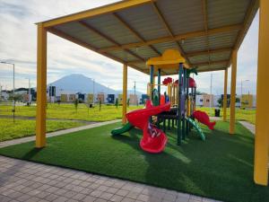 a playground in a park with red and green equipment at Casa Villa El Escape en Residencial Villa Panamericana in San Miguel