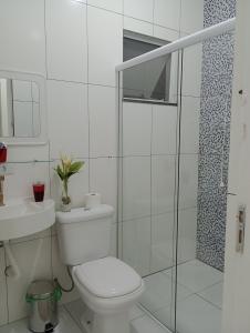 une salle de bain blanche avec toilettes et douche dans l'établissement Morada da praia, à Bertioga