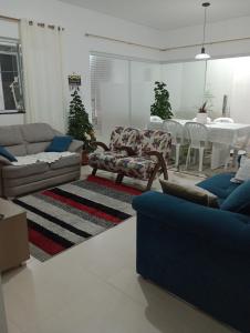 un salon avec des canapés et une table avec une salle à manger dans l'établissement Morada da praia, à Bertioga