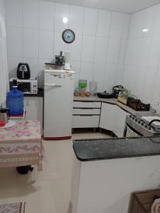 Il comprend une cuisine équipée d'un réfrigérateur blanc et d'une cuisinière. dans l'établissement Morada da praia, à Bertioga 3 autres photos