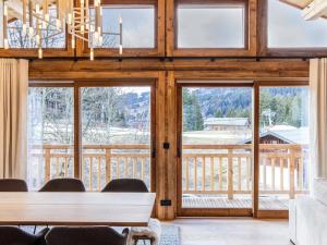 una sala da pranzo con ampie finestre e tavolo di Chalet de luxe aux Gets avec jacuzzi, sauna, Wi-Fi, parking - FR-1-671-272 a Les Gets