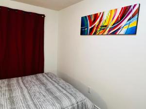 a bedroom with a bed and a painting on the wall at ComfyRoom in Toronto