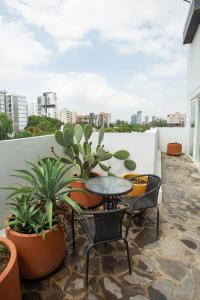 a balcony with a table and chairs and potted plants at Centrico departamento de 3 habitaciones in Guadalajara