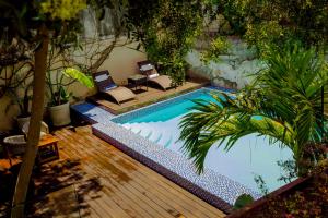 a swimming pool with two chairs and a table at Hotel Boutique Hacienda Guadalupe in San Miguel de Allende