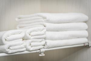 a stack of towels on a rack in a bathroom at エレガンス京町 -岡山市内中心部 路面電車の駅まで徒歩5分 のんびりステイ in Okayama +24 photos