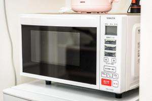 a microwave oven sitting on top of a shelf at エレガンス京町 -岡山市内中心部 路面電車の駅まで徒歩5分 のんびりステイ in Okayama