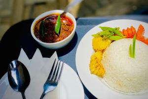 a plate of food with rice and a bowl of chili at Premium Cottages B&B in Kurunegala