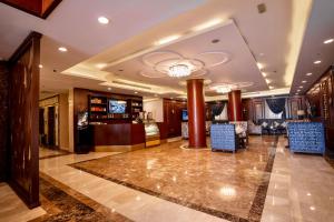 Laten Suites Al Naseem في جدة: بهو به كازينو مع كراسي زرقاء وطاولة