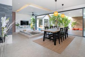 a dining room and living room with a table and chairs at Villa Kalliste 25 Phuket - Naiyang Beach in Ban Sakhu