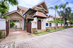 a house on a street with a driveway at Amazing Natcha villa in Pattaya