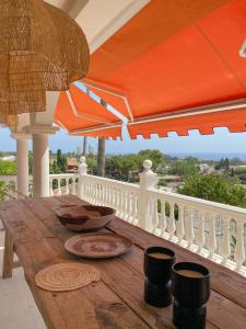 einen Holztisch mit Sonnenschirm auf dem Balkon in der Unterkunft Casa de Colina - great seaview - Marbella in Marbella