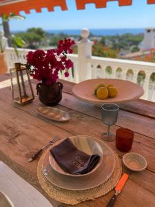 einem Holztisch mit Platten und einer Vase aus Blumen in der Unterkunft Casa de Colina - great seaview - Marbella in Marbella