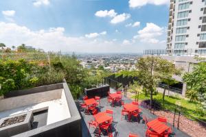 a group of red chairs and tables on a balcony at Adamant "El10" Depto 2 habitaciones Vista a Qro in Laborcillas
