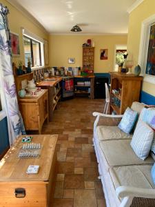 ein Wohnzimmer mit Sofa und Tisch in der Unterkunft Kahurangi Cottage Wilderness Retreat in Stanley Brook